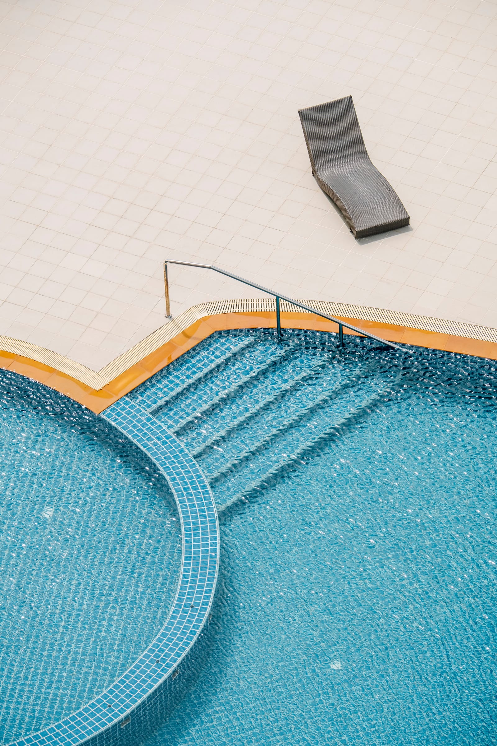 A swimming pool viewed from above, calm water ready for the season